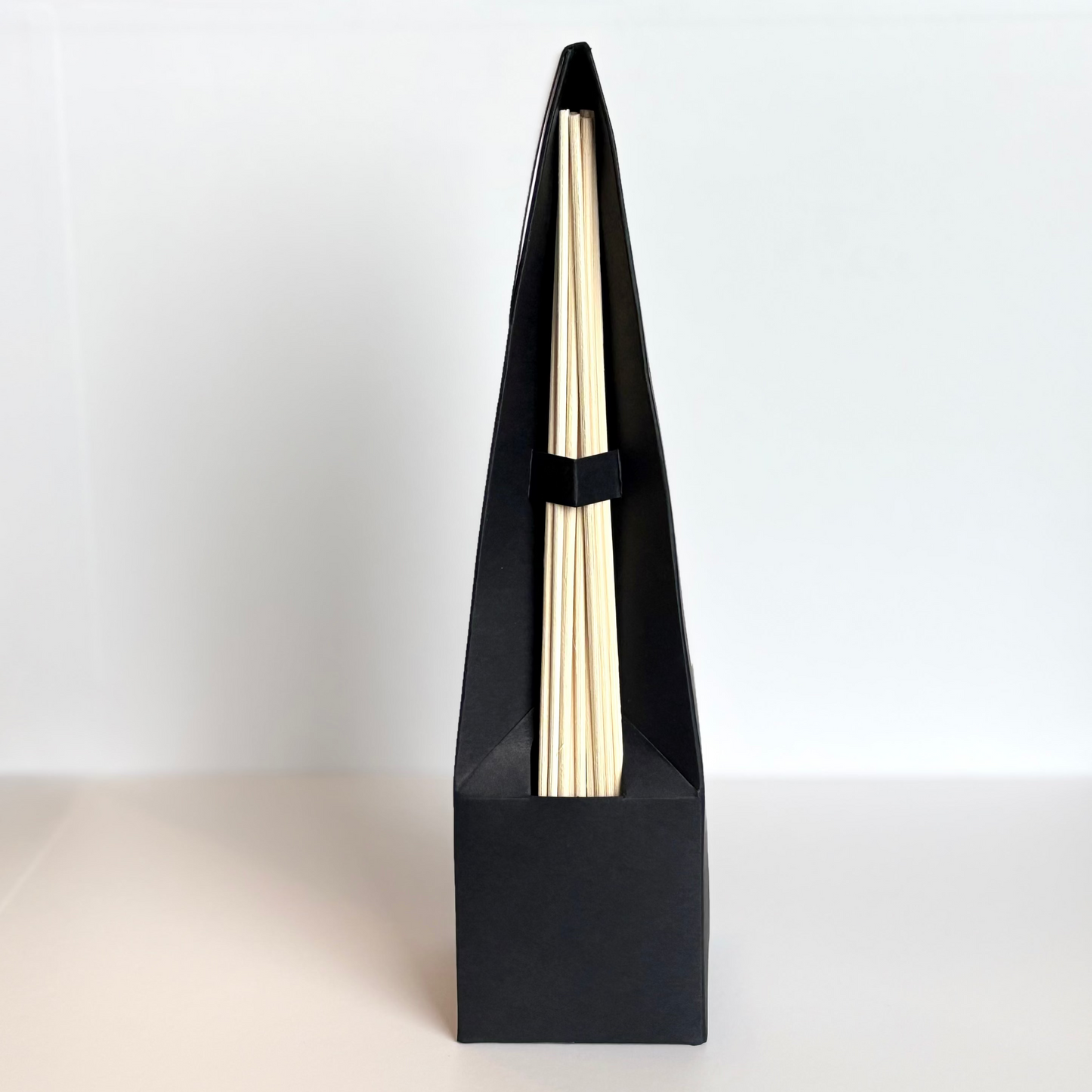 Black triangular box with a gold interior on a white background