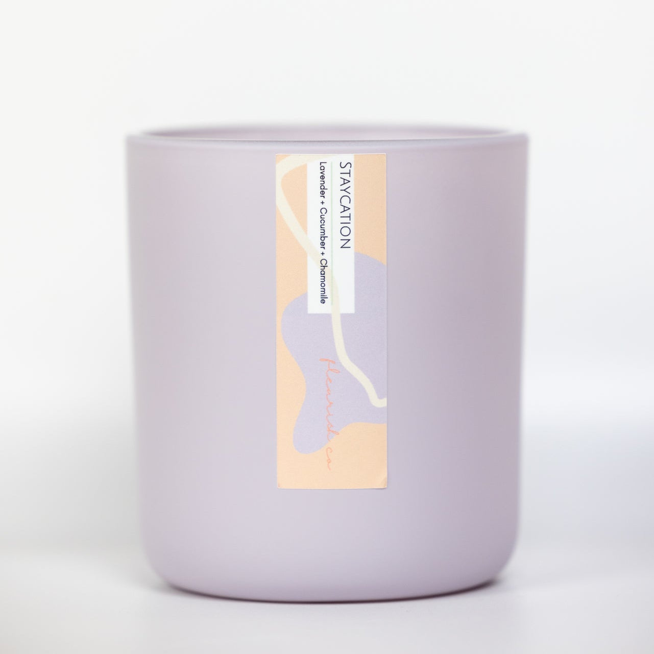 Purple candle with a label on a white background