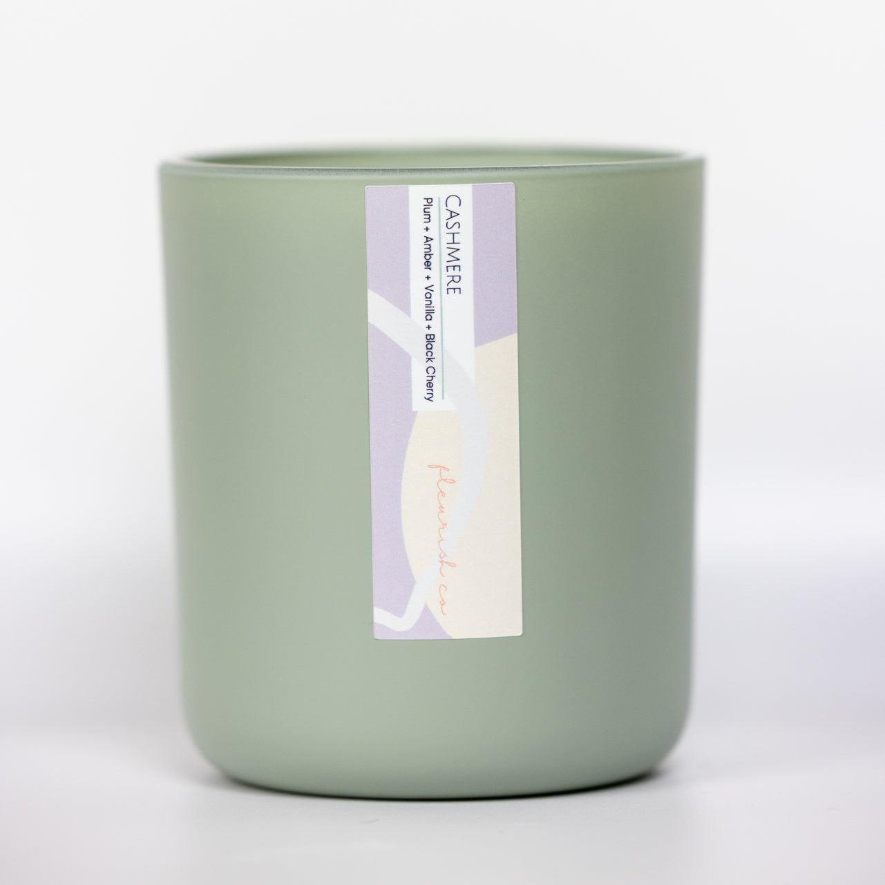 Green candle with a label on a white background