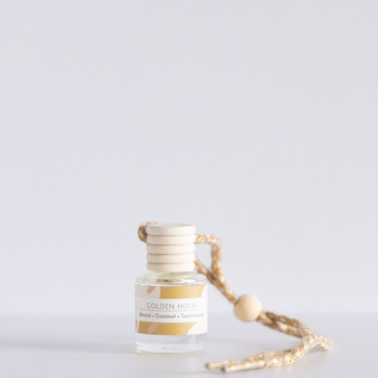 Small bottle with a label and a rope on a light gray background