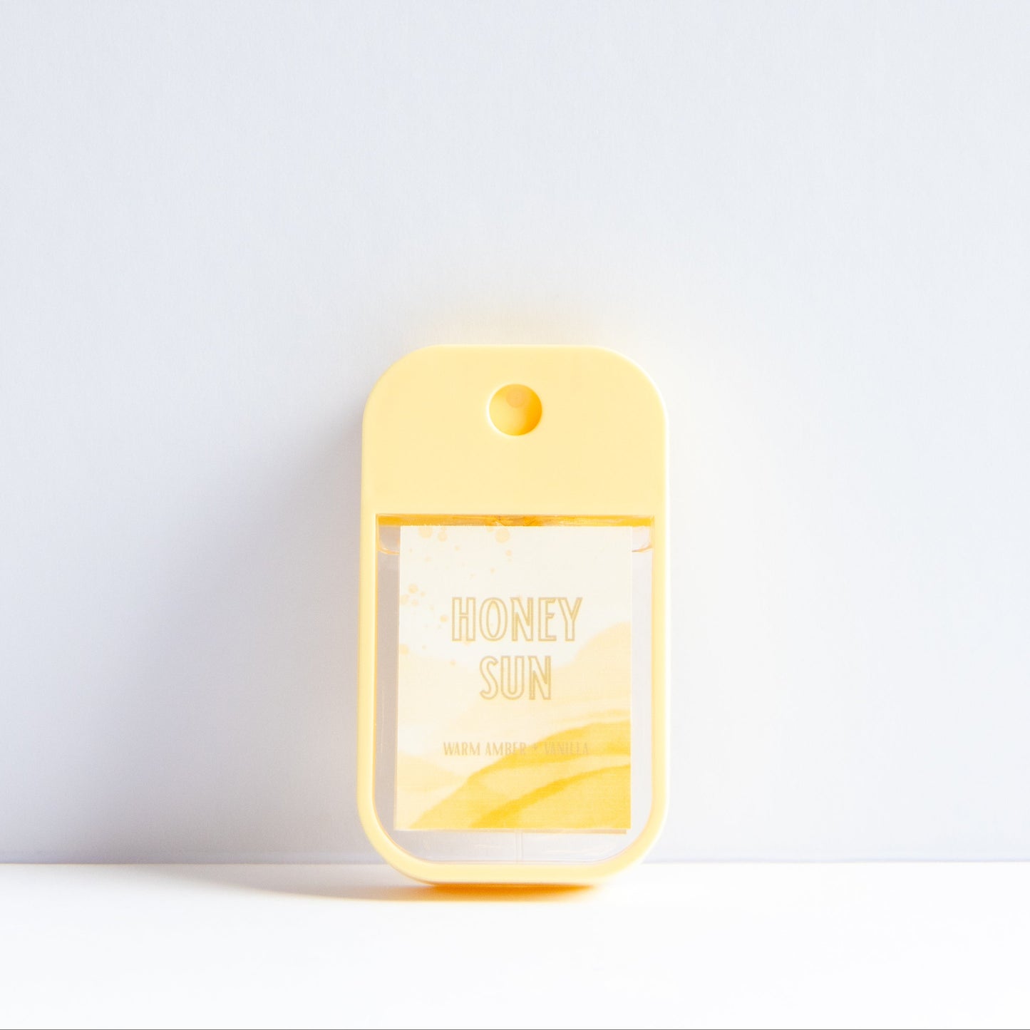 A small yellow honey-themed card holder or pocket clip with a clear window showing a honey packet labeled 'HONEY SUN', set against a clean white background.