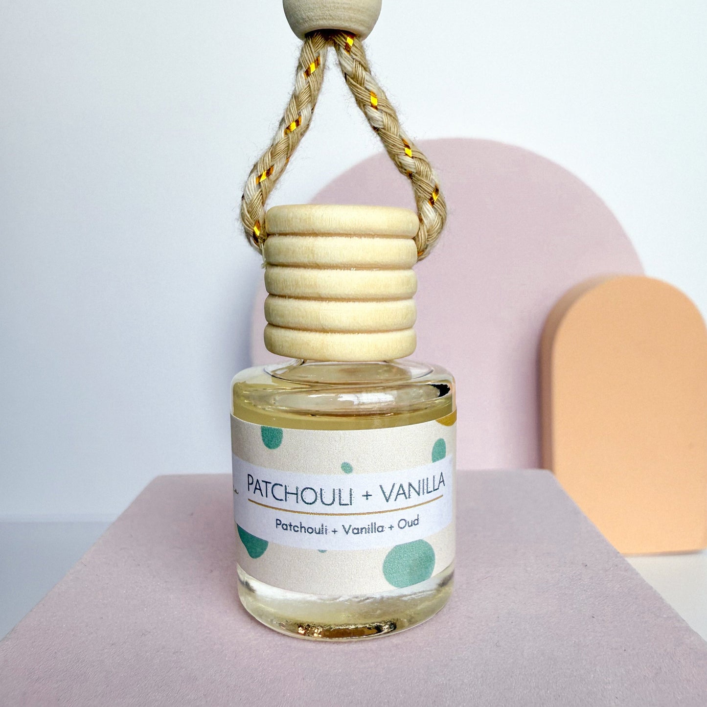 Patchouli Vanilla perfume bottle with wooden cap on a neutral background