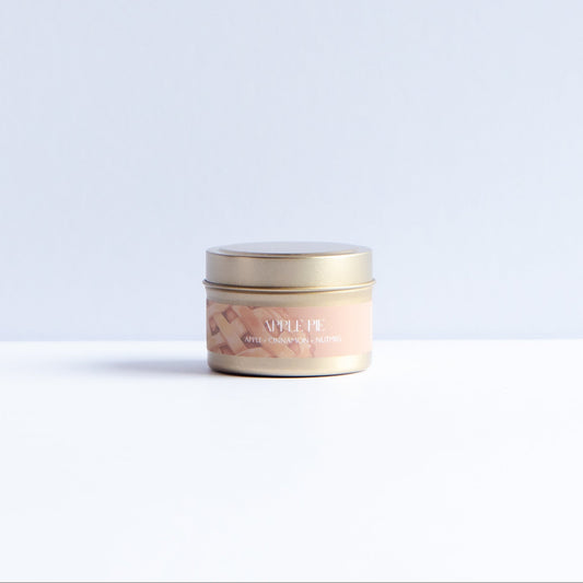 A small round cosmetic jar with a gold lid and a light peach label reading 'LUXE' and 'Rose', placed on a white surface against a pale blue-gray background.