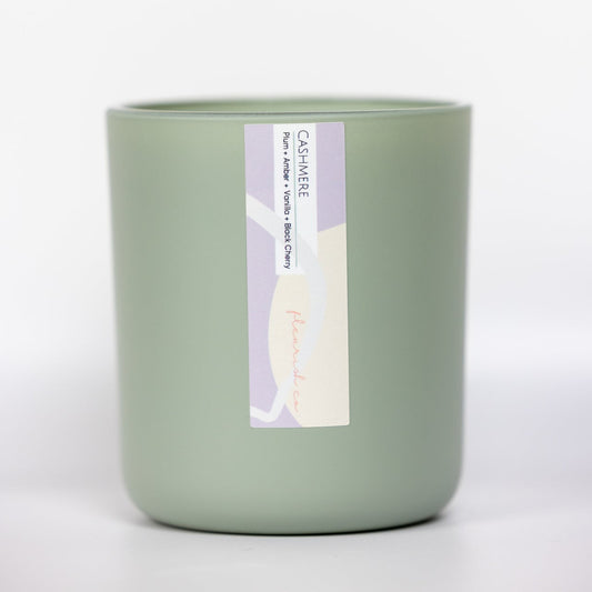 Green candle with a label on a white background