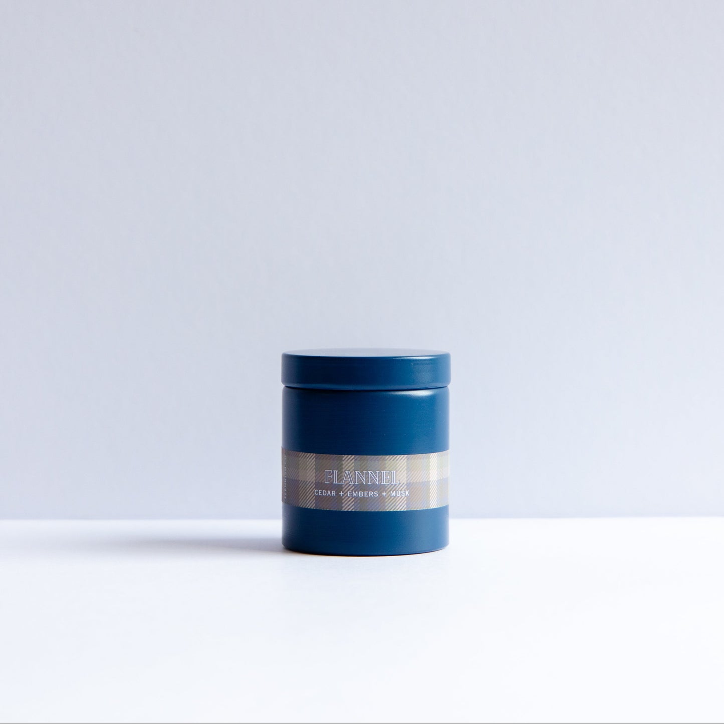 A small cylindrical blue jar with a metallic silver label reading 'FLENNER' and 'SKIN CARE JAR' on a clean white surface against a light gray background.