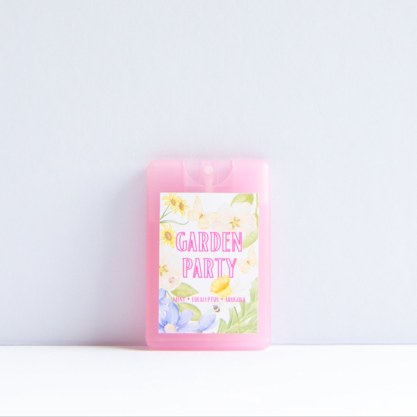 A pink rectangular wax melt or scented melt package with a floral 'GARDEN PARTY' label, standing upright on a white surface against a light gray background.
