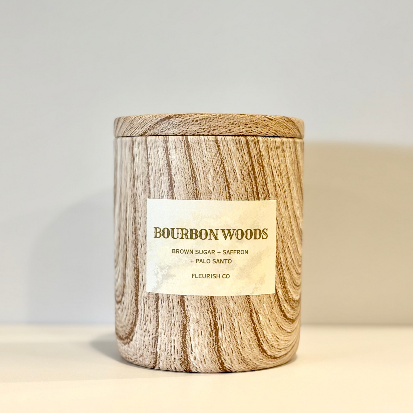 Candle with wooden design and label on a neutral background