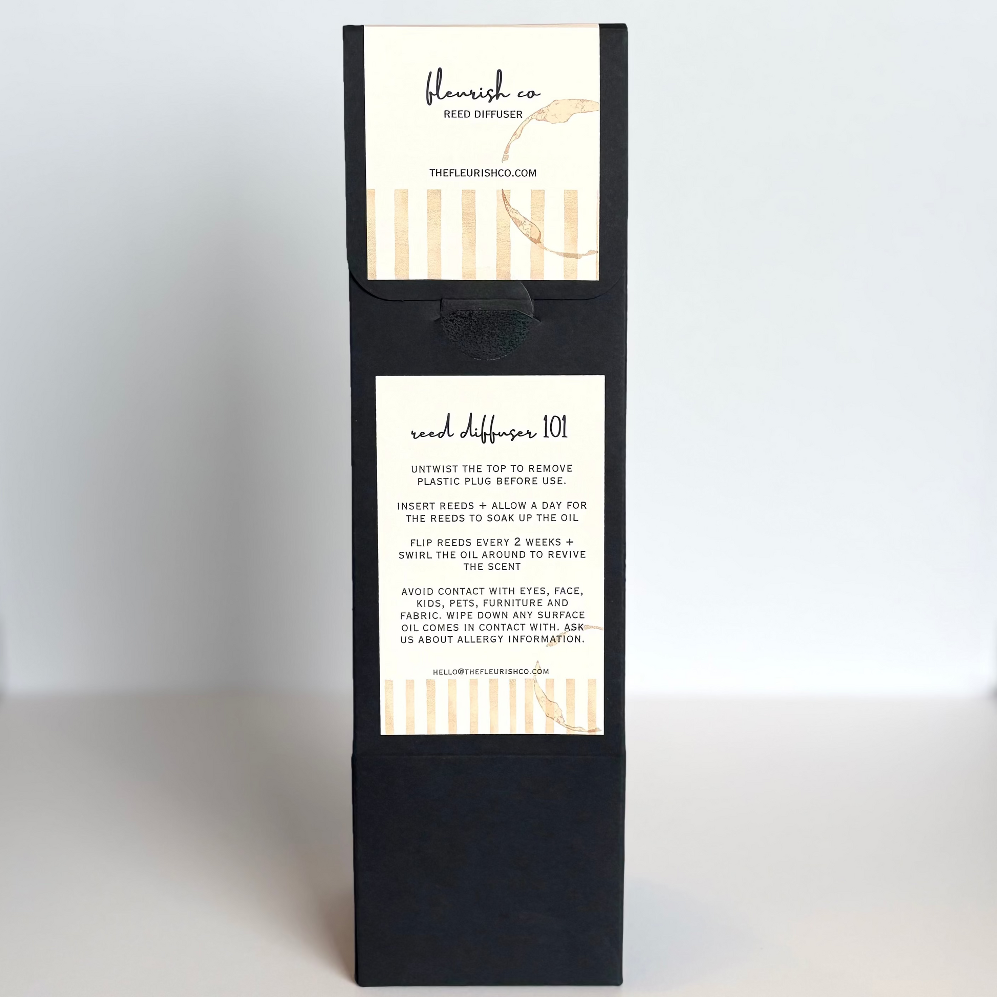 Black gift box with white labels on a white surface