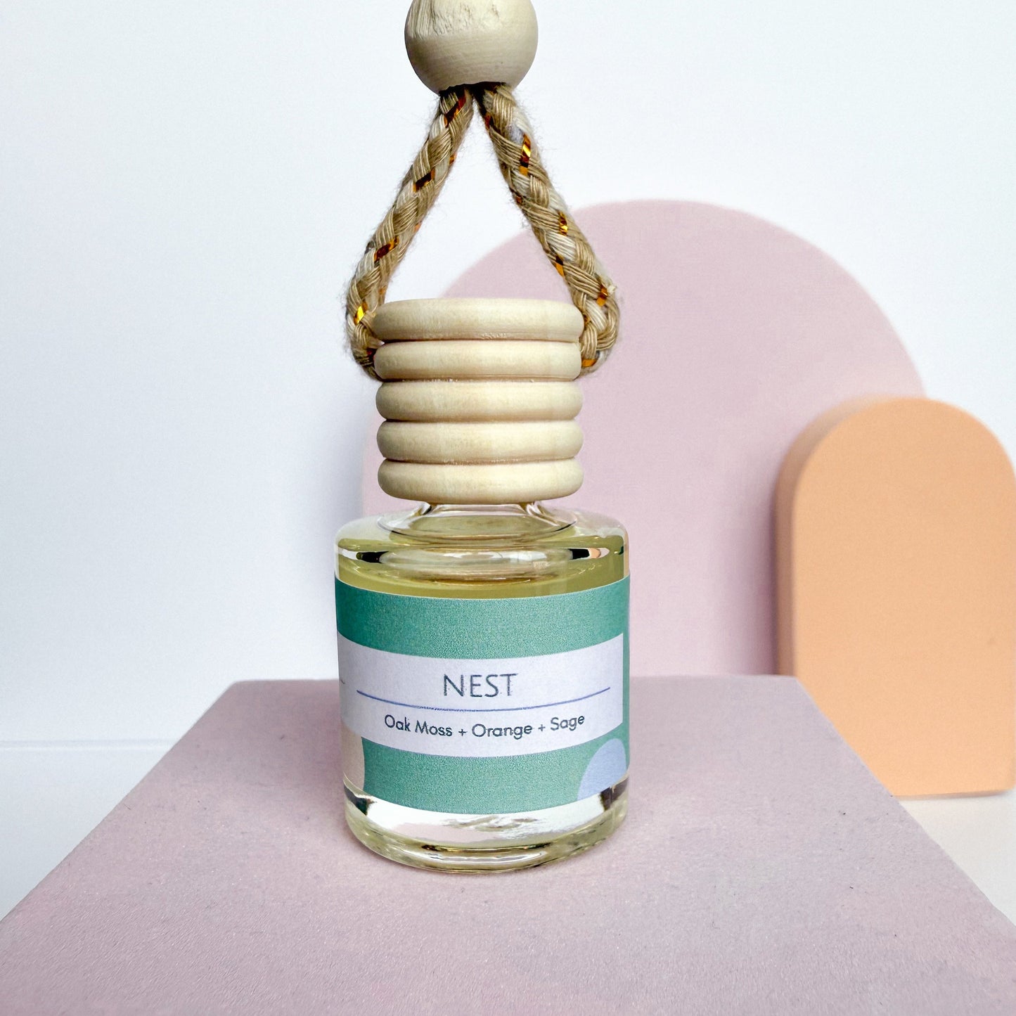 Decorative diffuser with wooden elements on a pink surface