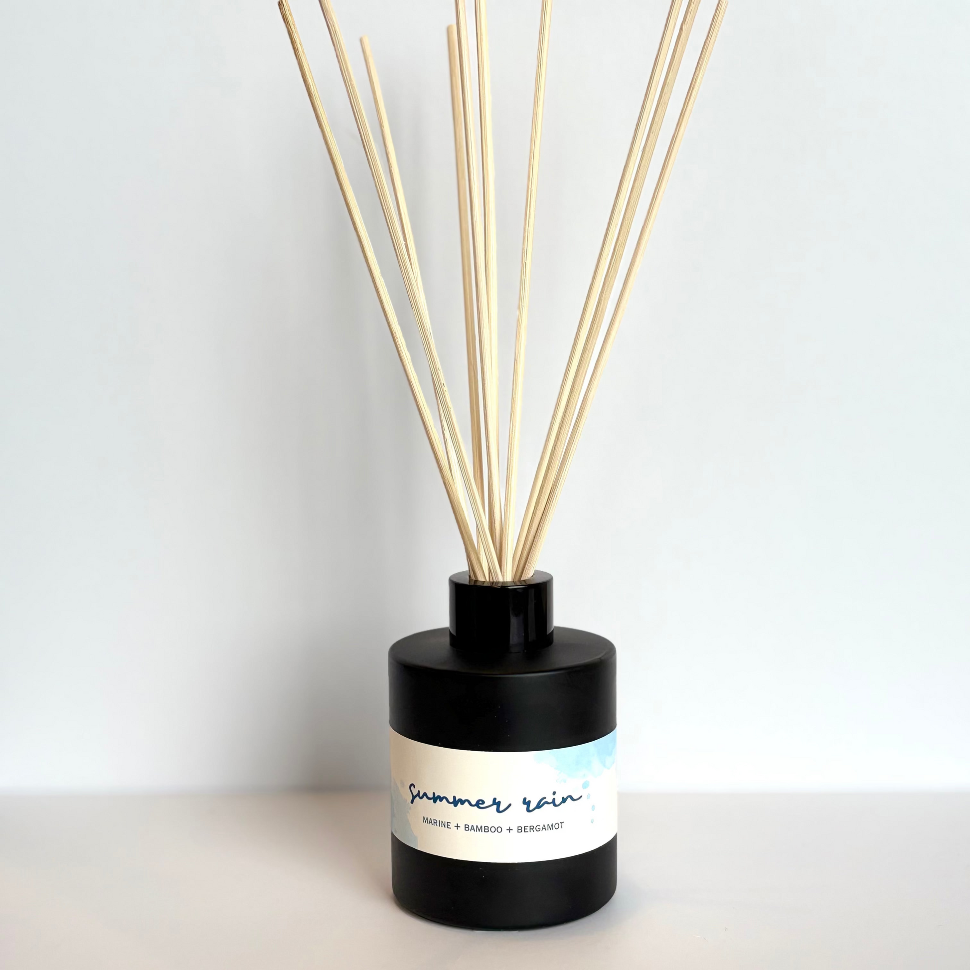 Black diffuser bottle with wooden sticks on a white background