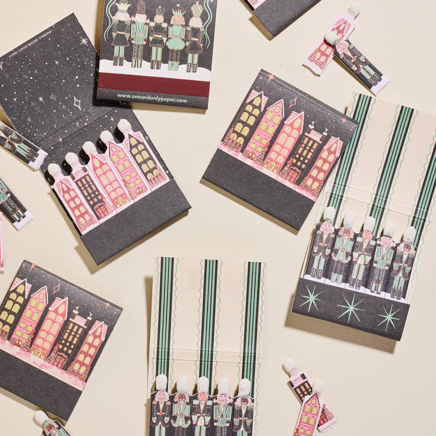 Set of small matchbooks and matches with colorful illustrations on a beige background