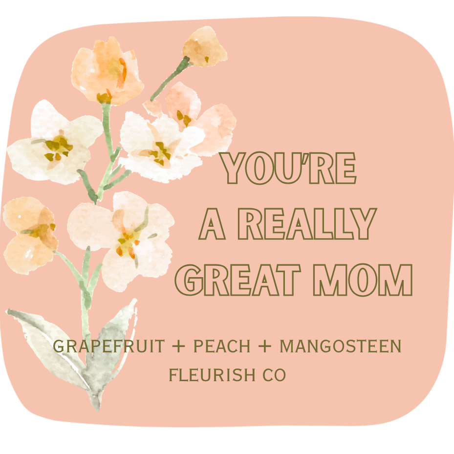 Candle label with floral design and text on a peachy pink background