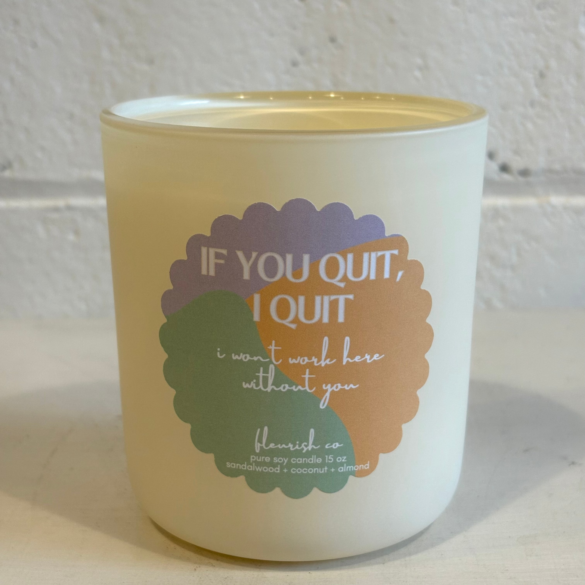 Candle with motivational quote on a textured surface